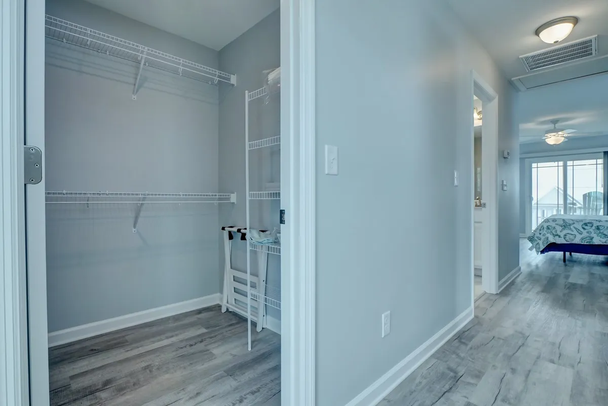 The image presents closet shelving and open storage space, accentuated by clean white walls and practical flooring. The ample shelving indicates the home's readiness for extended stays and organization, hinting at linen storage and overall convenience.